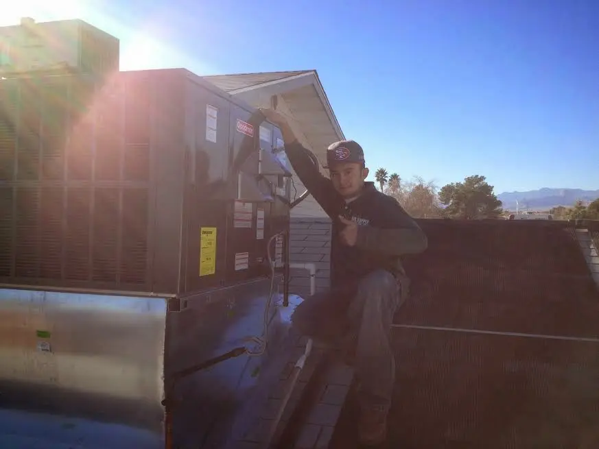 HVAC technician performing Air Duct Cleaning on a rooftop unit in Lathrop